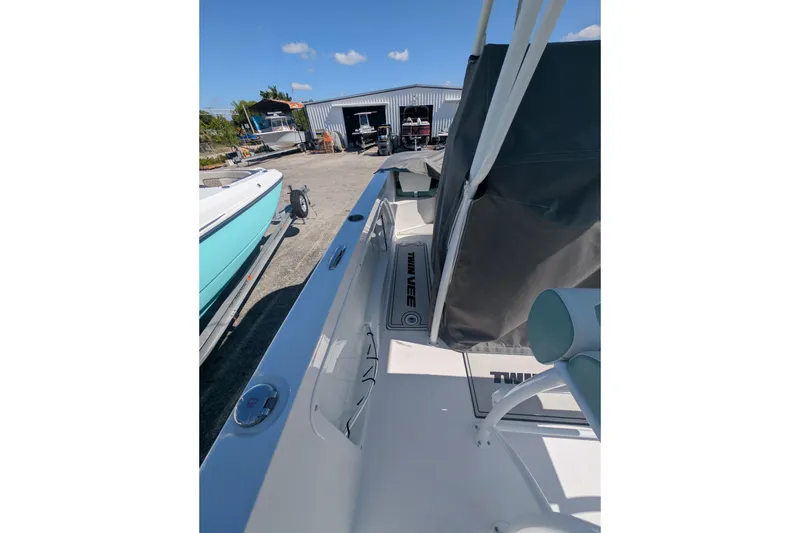 Slide: The Image of 2024 Twin Vee 240 GFX CC boat docked outdoors under clear blue sky. - 9