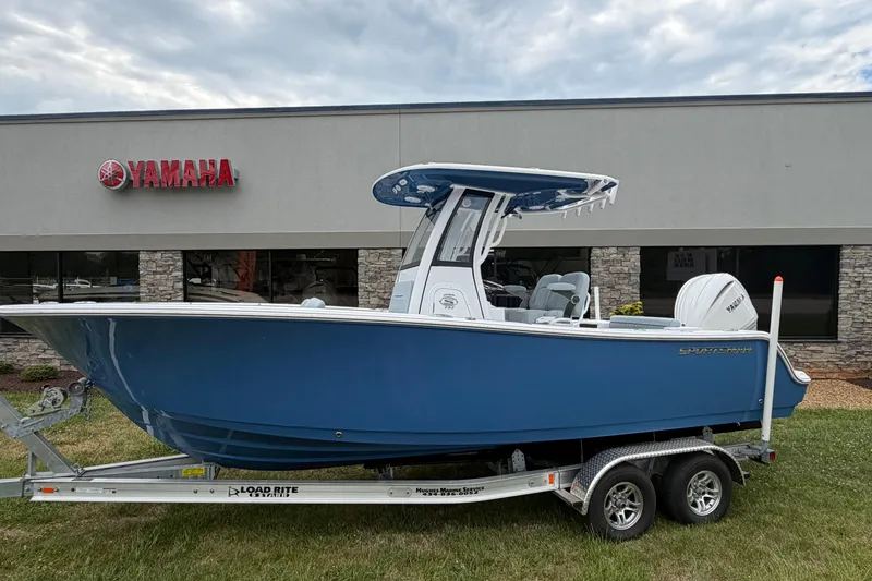 The Image of 2026 Sportsman Open 232 Center Console boat on trailer outside Yamaha dealership. - 1