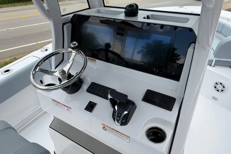 Slide: The Image of 2026 Sportsman Open 232 Center Console boat dashboard with steering wheel and navigation screens. - 12
