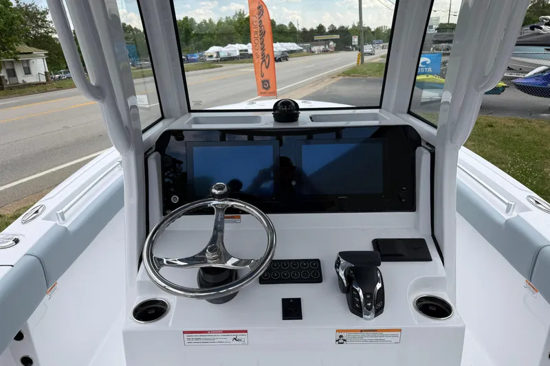 Slide: The Image of 2026 Sportsman Open 232 Center Console boat dashboard with dual screens and steering wheel. - 15