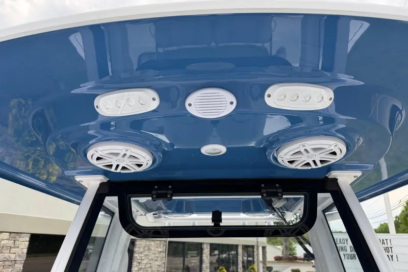 Slide: The Image of 2026 Sportsman Open 232 Center Console boat with blue T-top and integrated speakers. - 9
