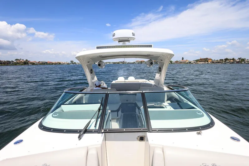 Slide: The Image of 2022 Sea Ray SLX 310 Outboard cruising on a sunny day, showcasing sleek design and luxury. - 13