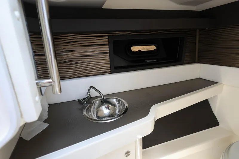 Slide: The Image of 2022 Sea Ray SLX 310 Outboard cabin interior with sink and window. - 18