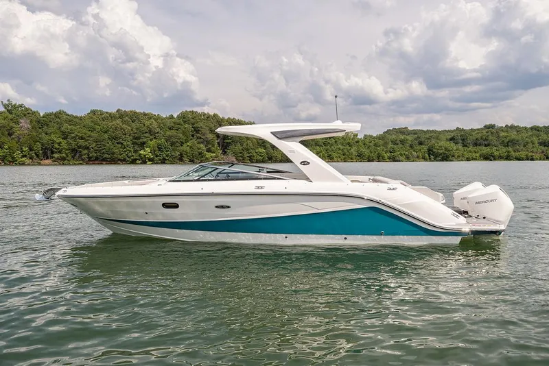 Slide: The Image of Manufacturer Provided Image: 2022 Sea Ray SLX 310 OB boat on a lake with a forested shoreline. - 2