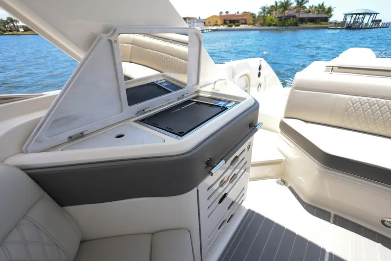 Slide: The Image of 2022 Sea Ray SLX 310 Outboard boat interior with seating and storage, near waterfront. - 22