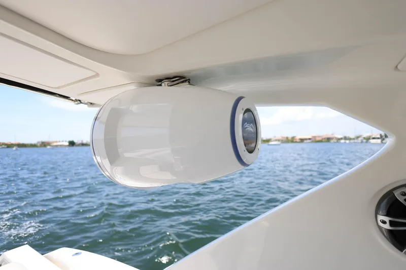 Slide: The Image of 2022 Sea Ray SLX 310 Outboard speaker system on a boat, overlooking a scenic water view. - 23