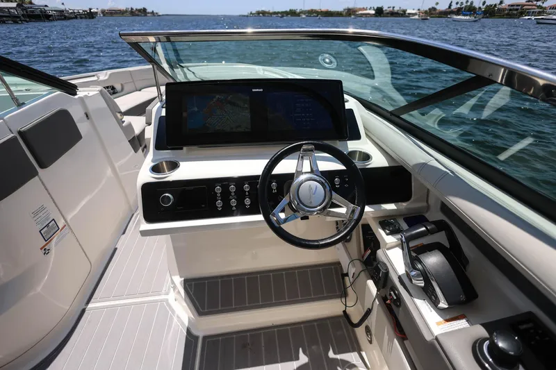 Slide: The Image of 2022 Sea Ray SLX 310 Outboard helm with modern controls and navigation display. - 27