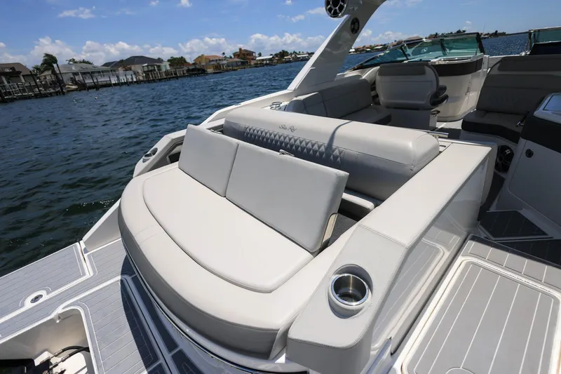 Slide: The Image of Luxurious seating on a 2022 Sea Ray SLX 310 Outboard boat, with scenic waterfront views. - 32