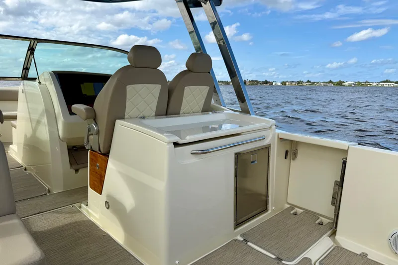 Slide: The Image of 2023 Chris-Craft Calypso 30 boat interior with seating, helm, and water view. - 14