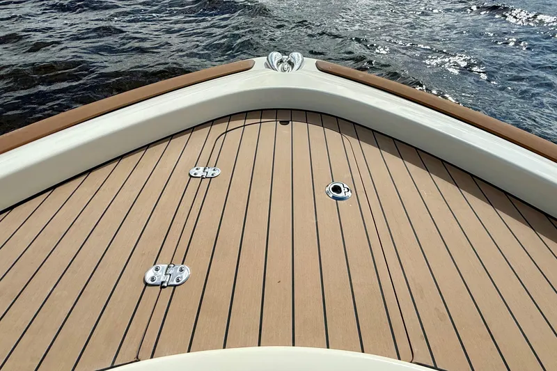 Slide: The Image of Bow of 2023 Chris-Craft Calypso 30 with teak decking on water. - 22