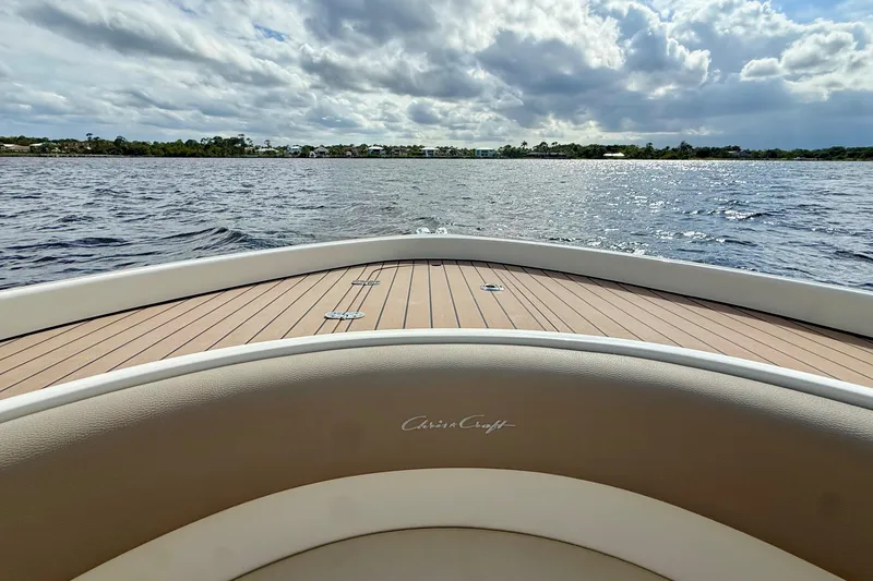 Slide: The Image of 2023 Chris-Craft Calypso 30 boat on water, cloudy sky, wooden deck. - 23