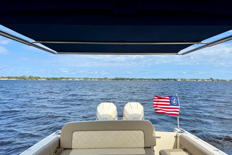 Slide: The Image of 2023 Chris-Craft Calypso 30 boat with American flag on open water. - 25