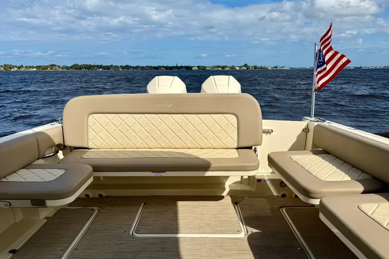 Slide: The Image of 2023 Chris-Craft Calypso 30 boat interior with beige seating and American flag. - 27