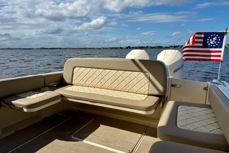 Slide: The Image of 2023 Chris-Craft Calypso 30 boat interior with seating and nautical flag on open water. - 28