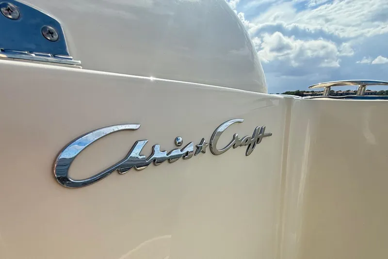 Slide: The Image of 2023 Chris-Craft Calypso 30 boat with logo, under a partly cloudy sky. - 31