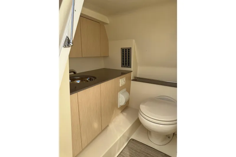 Slide: The Image of 2023 Chris-Craft Calypso 30 boat bathroom with modern fixtures and wooden cabinetry. - 32