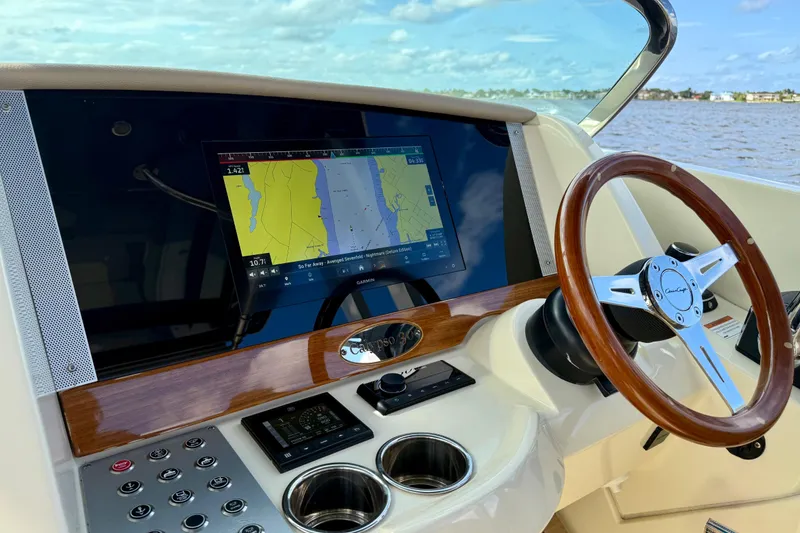 Slide: The Image of 2023 Chris-Craft Calypso 30 helm with navigation display and wooden steering wheel. - 4