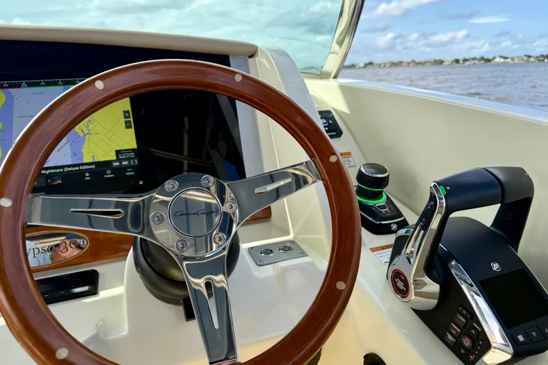 Slide: The Image of 2023 Chris-Craft Calypso 30 helm with wooden steering wheel and navigation display. - 6
