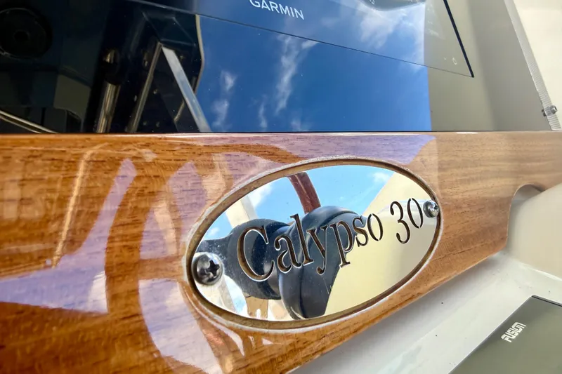 Slide: The Image of Close-up of 2023 Chris-Craft Calypso 30 nameplate on polished wood panel. - 7