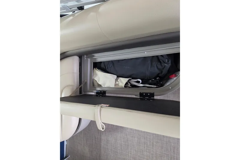 Slide: The Image of 2023 Sun Tracker Bass Buggy 16 XL storage compartment with gear inside. - 8