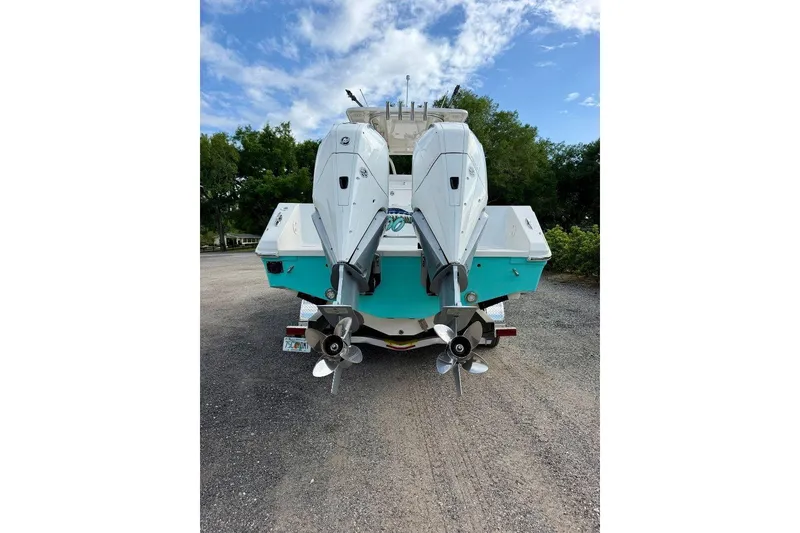 Slide: The Image of 2009 SeaHunter 29 Center Console boat with dual outboard motors, parked on gravel. - 3