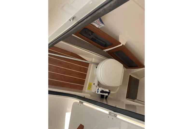 Slide: The Image of 2019 Grady-White Freedom 235 boat interior with toilet and wooden accents. - 12