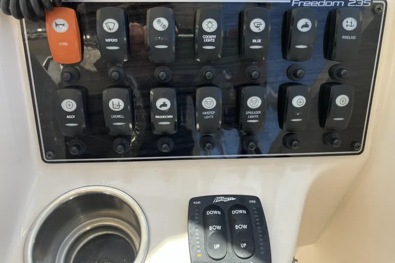 Slide: The Image of Control panel of 2019 Grady-White Freedom 235 boat with various switches and buttons. - 16