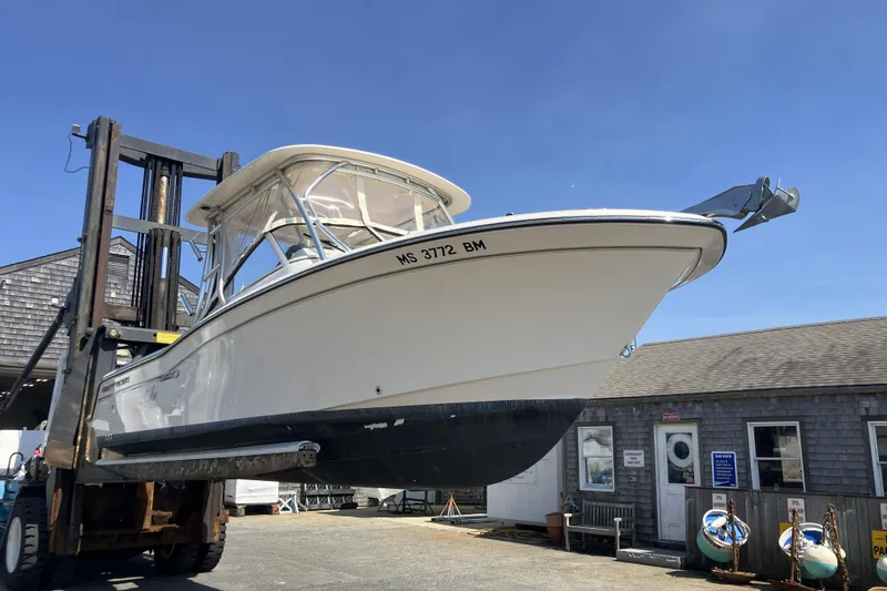 Slide: The Image of 2019 Grady-White Freedom 235 boat lifted by forklift near a building. - 20