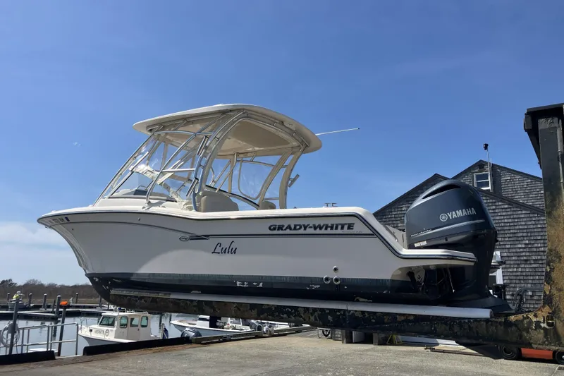 Slide: The Image of 2019 Grady-White Freedom 235 boat with Yamaha engine on a lift, clear sky background. - 22