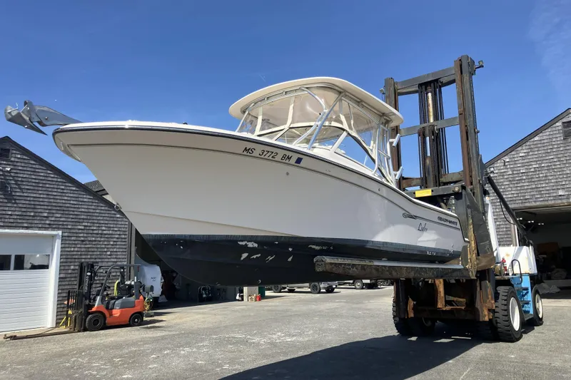 Slide: The Image of 2019 Grady-White Freedom 235 boat lifted by forklift in marina. - 23