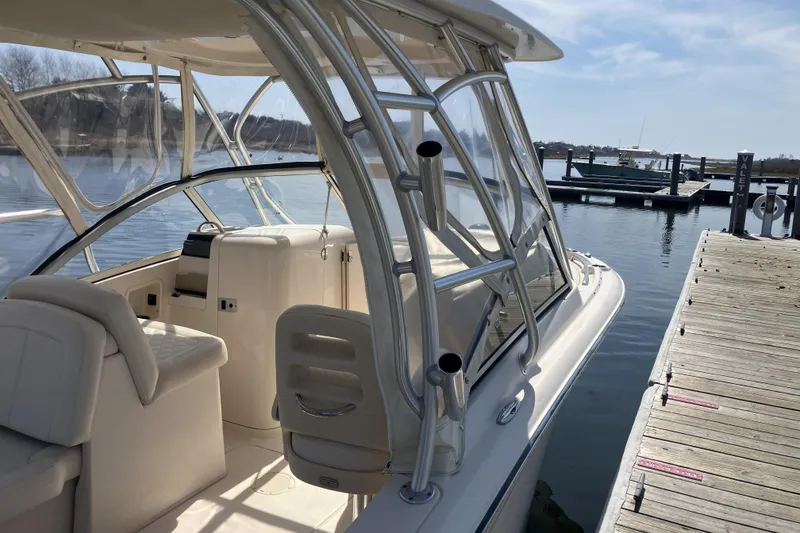 Slide: The Image of 2019 Grady-White Freedom 235 boat docked, showcasing interior seating and helm. - 3