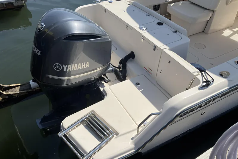 Slide: The Image of 2019 Grady-White Freedom 235 boat with Yamaha outboard motor, docked on calm water. - 4