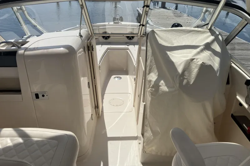 Slide: The Image of 2019 Grady-White Freedom 235 boat interior with covered seating and dock view. - 5