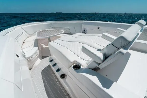 Slide: The Image of 2022 Intrepid 407 Nomad FE boat interior with white seating and ocean view. - 10