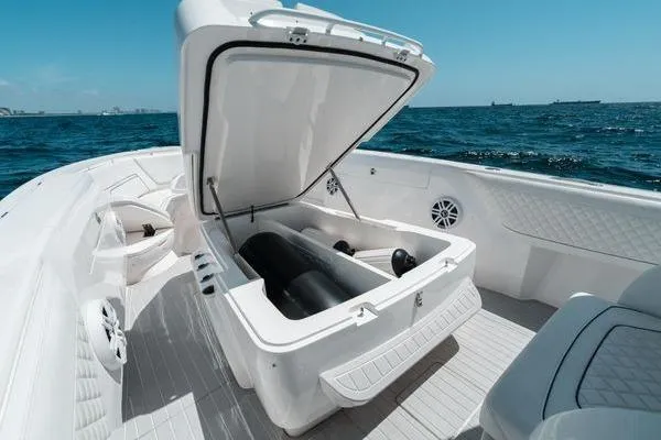 Slide: The Image of 2022 Intrepid 407 Nomad FE boat with open storage compartment on deck, ocean background. - 11