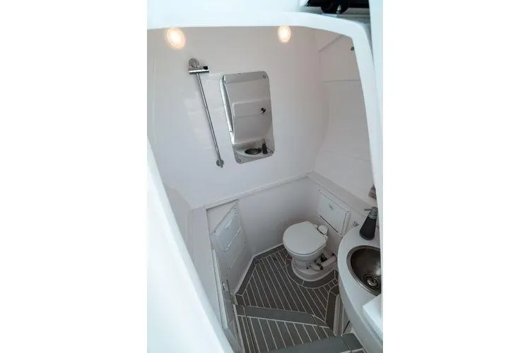 Slide: The Image of 2022 Intrepid 407 Nomad FE boat bathroom with toilet, sink, and mirror. - 12
