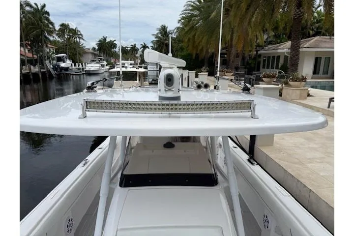 Slide: The Image of 2022 Intrepid 407 Nomad FE boat docked near palm trees and waterfront homes. - 15