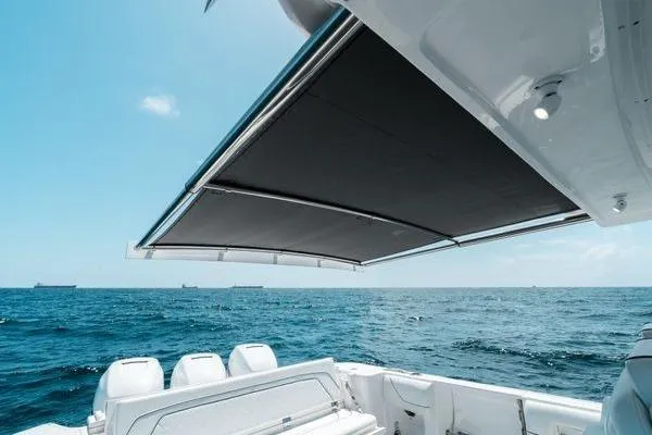 Slide: The Image of 2022 Intrepid 407 Nomad FE boat with extended sunshade on open sea. - 16