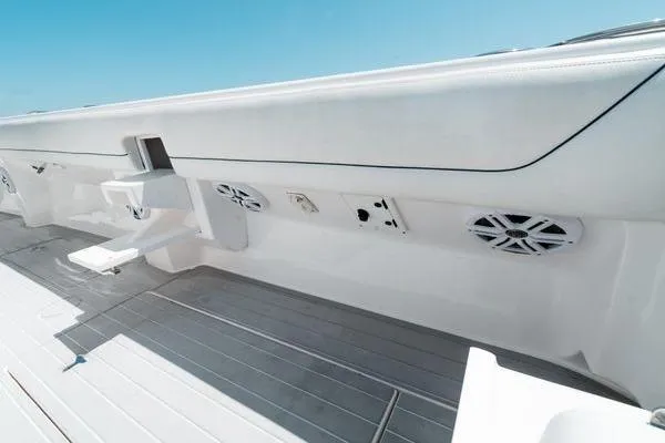 Slide: The Image of 2022 Intrepid 407 Nomad FE boat interior with sleek white design and built-in speakers. - 17