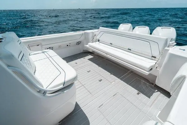 Slide: The Image of 2022 Intrepid 407 Nomad FE boat interior with white seating, ocean backdrop. - 2