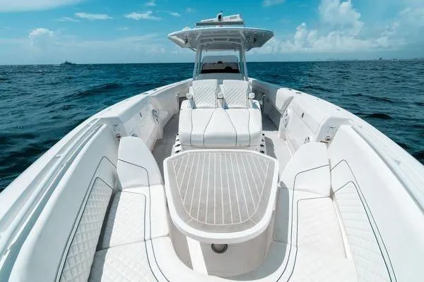 Slide: The Image of 2022 Intrepid 407 Nomad FE boat on open ocean, featuring sleek white design and spacious seating. - 4