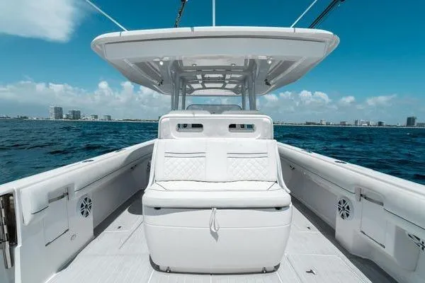 Slide: The Image of 2022 Intrepid 407 Nomad FE boat on open water, featuring sleek white seating. - 5