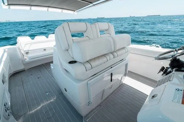 Slide: The Image of 2022 Intrepid 407 Nomad FE boat interior with white seating, ocean view. - 6
