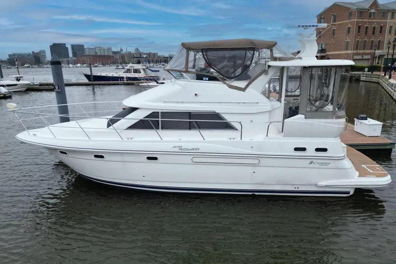 The Image of 2005 Cruisers Yachts 375 Motoryacht docked in a marina with cityscape background. - 0