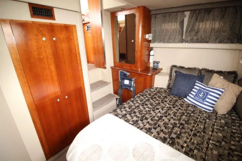 Slide: The Image of Luxurious 2005 Cruisers Yachts 375 Motoryacht bedroom with cozy bedding and wooden cabinetry. - 27