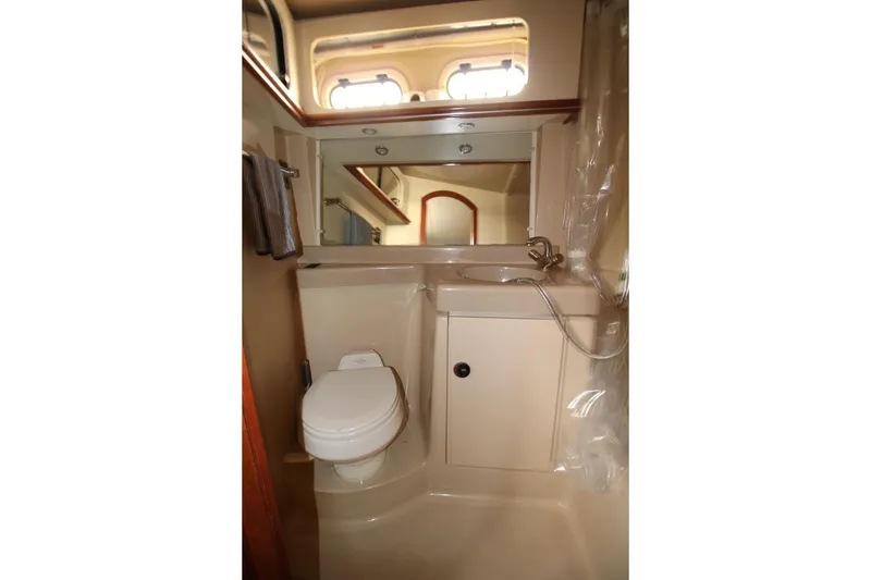 Slide: The Image of 2005 Cruisers Yachts 375 Motoryacht bathroom with toilet, sink, and mirror. - 28