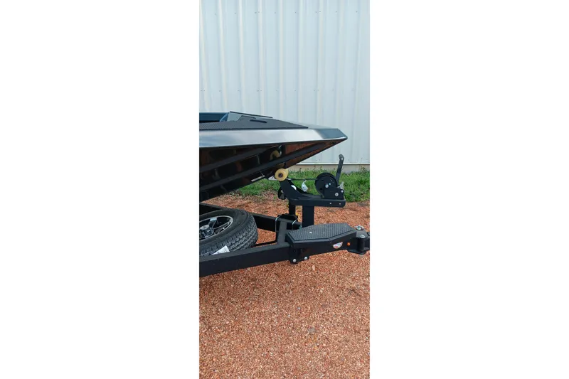 Slide: The Image of 2026 Ranger RT188C boat trailer hitch on gravel, near a metal building. - 22