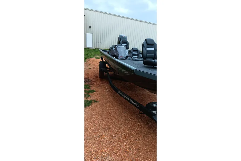 Slide: The Image of 2026 Ranger RT188C boat on a trailer, parked on gravel near a building. - 7