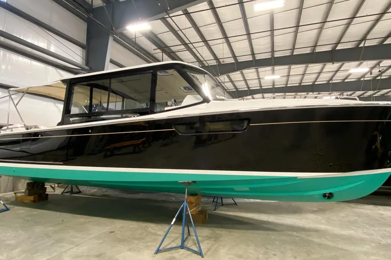 The Image of 2022 MJM 3 boat in a warehouse, black hull with teal bottom. - 46