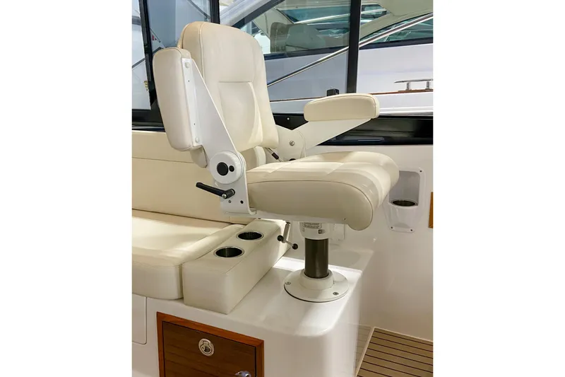 Slide: The Image of Captain's chair on 2022 MJM 3 boat, featuring beige upholstery and adjustable armrests. - 52